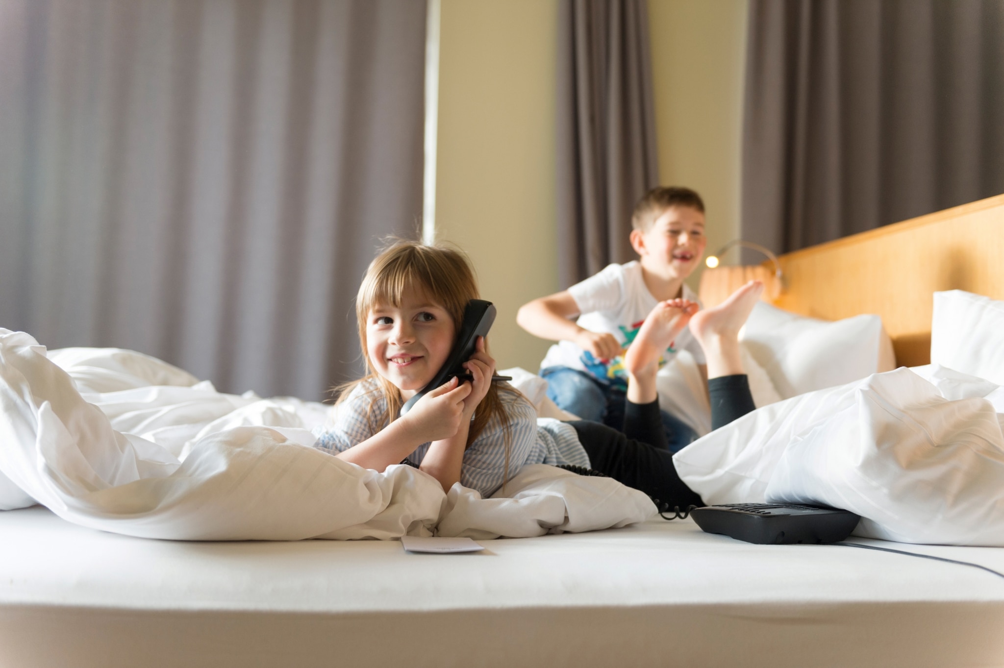 Kinder telefonieren im Bett im ULRICHSHOF