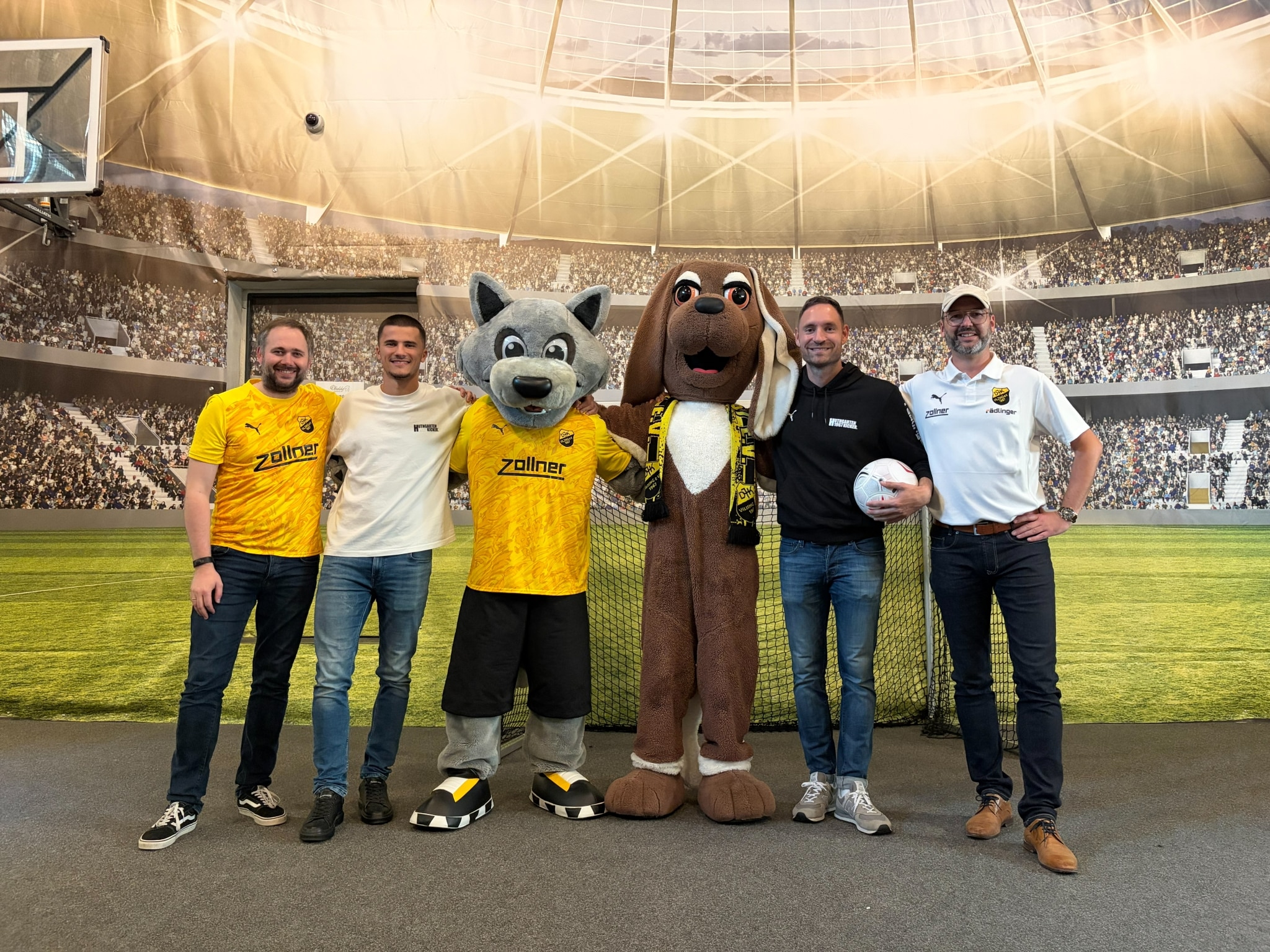 Der ULRICHSHOF ist Comfortpartner vom DJK Vilzing. Gruppenfoto mit Niklaus Brandl von der ULRICHSHOF Geschäftsleitung, Martin Mihaylov, Innenverteidiger (#13), Maskottchen Vilzi und Yolybsi, Markus Ziereis, Stürmer #11 Stefan Schmidbauer, 2. Abteilungsleiter Fußball & Betreuung Businesspartner